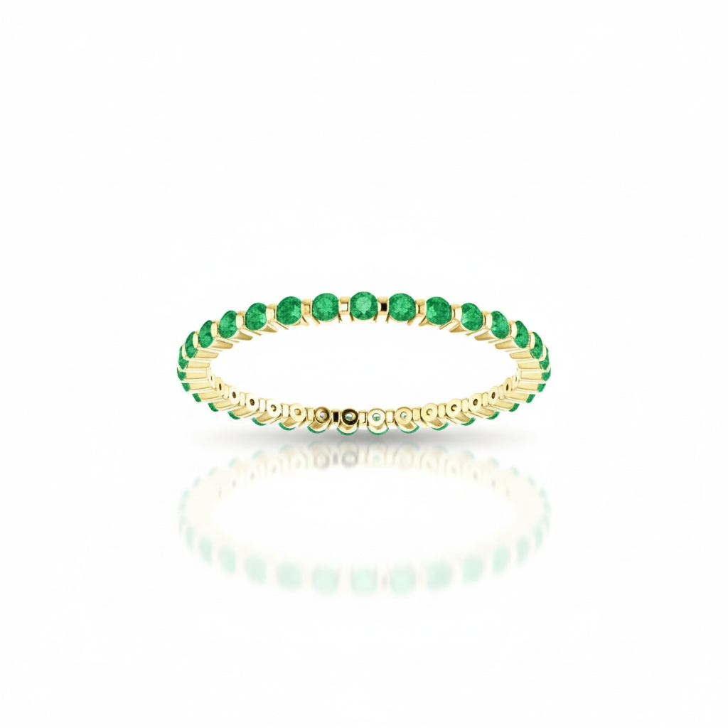 Gold ring with green emerald gemstones on a white background