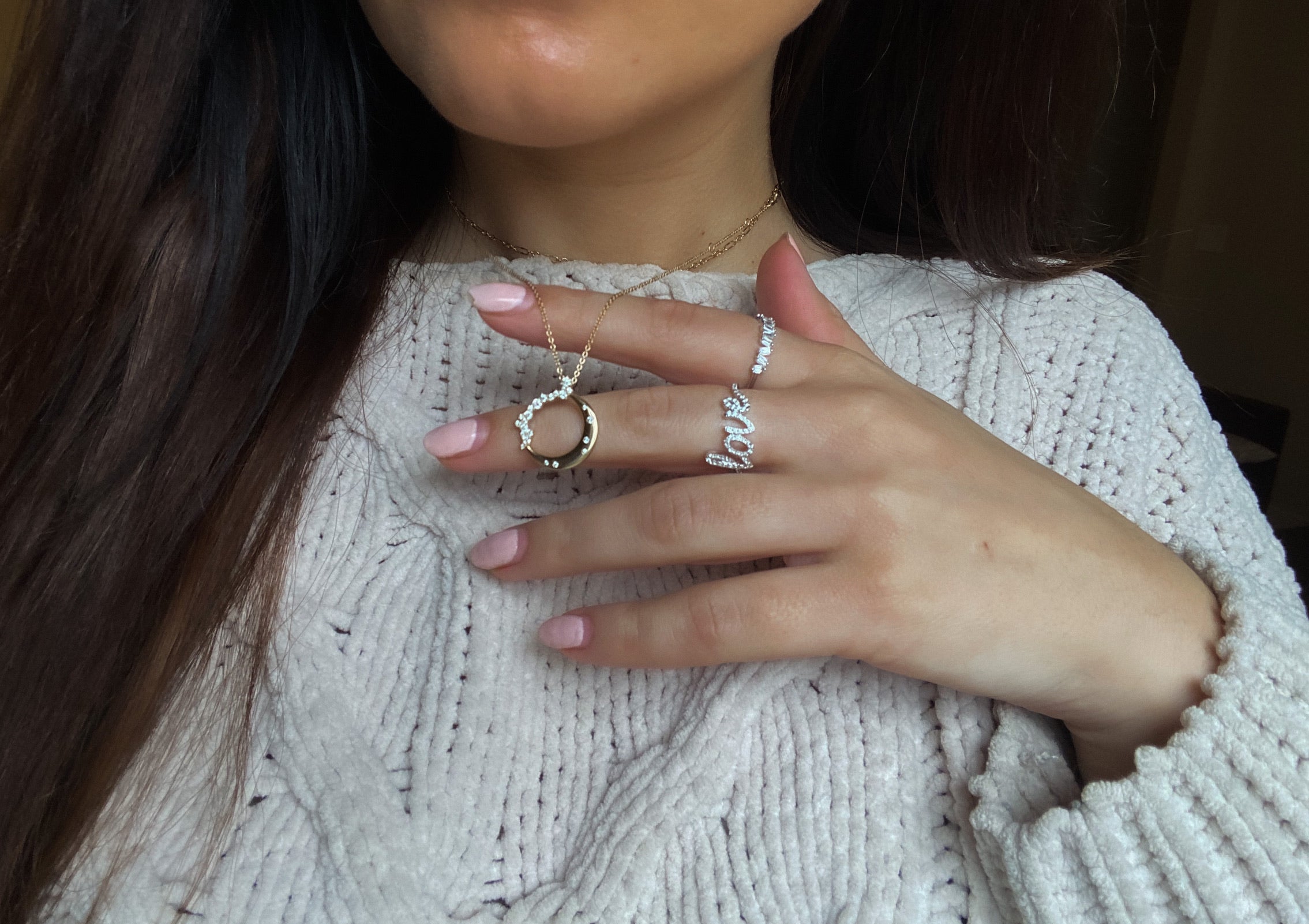 A woman wearing moon shaped 14k gold necklace with diamonds on a 14k gold chain
