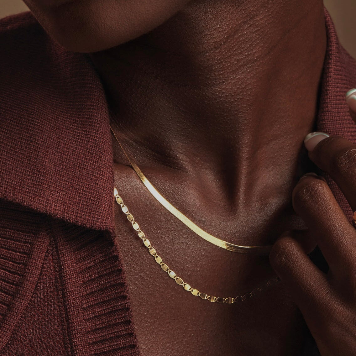 Mirror link necklace layered on a model's neck