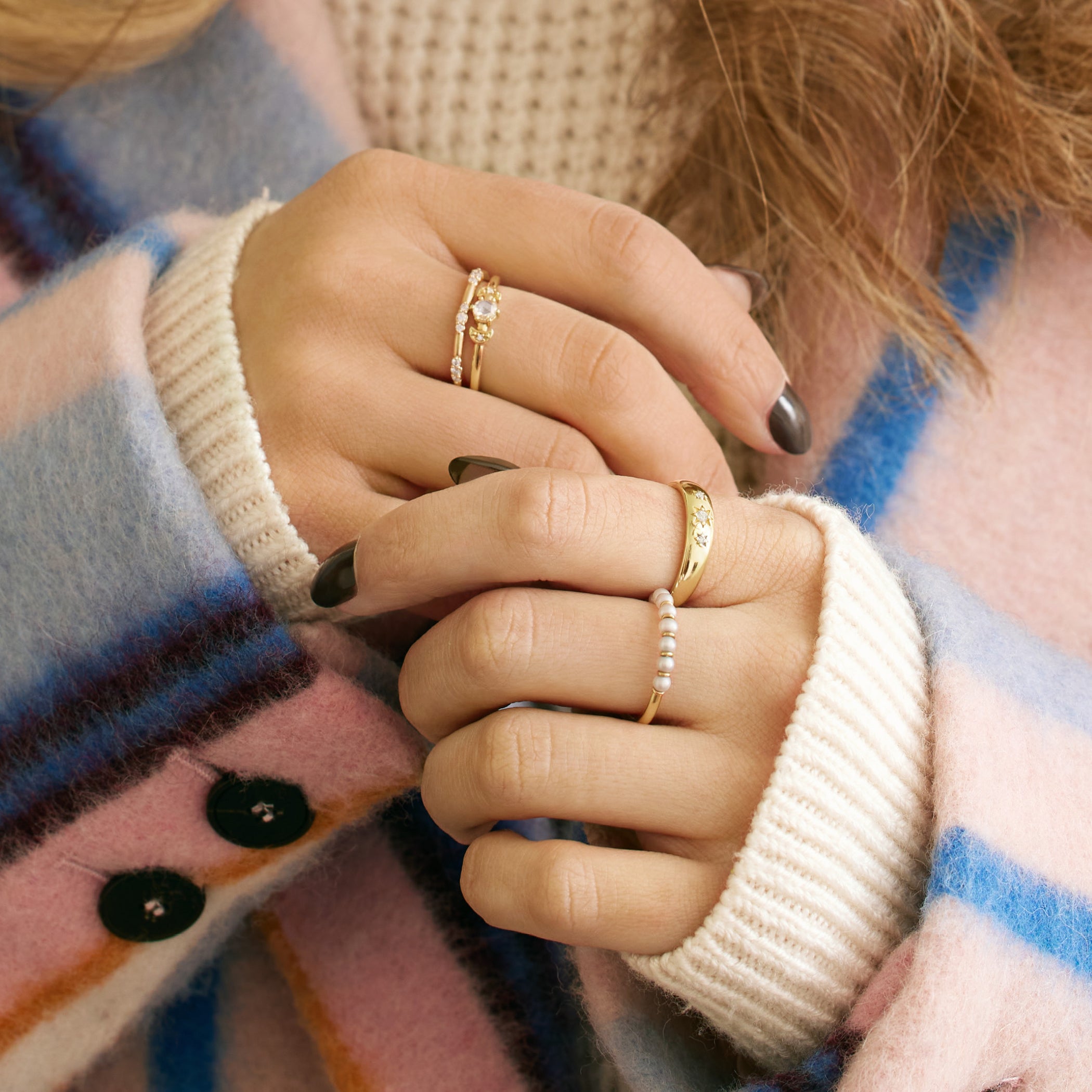 Woman is wearing 14k Gold Pearl Ring stacked with other diamond rings