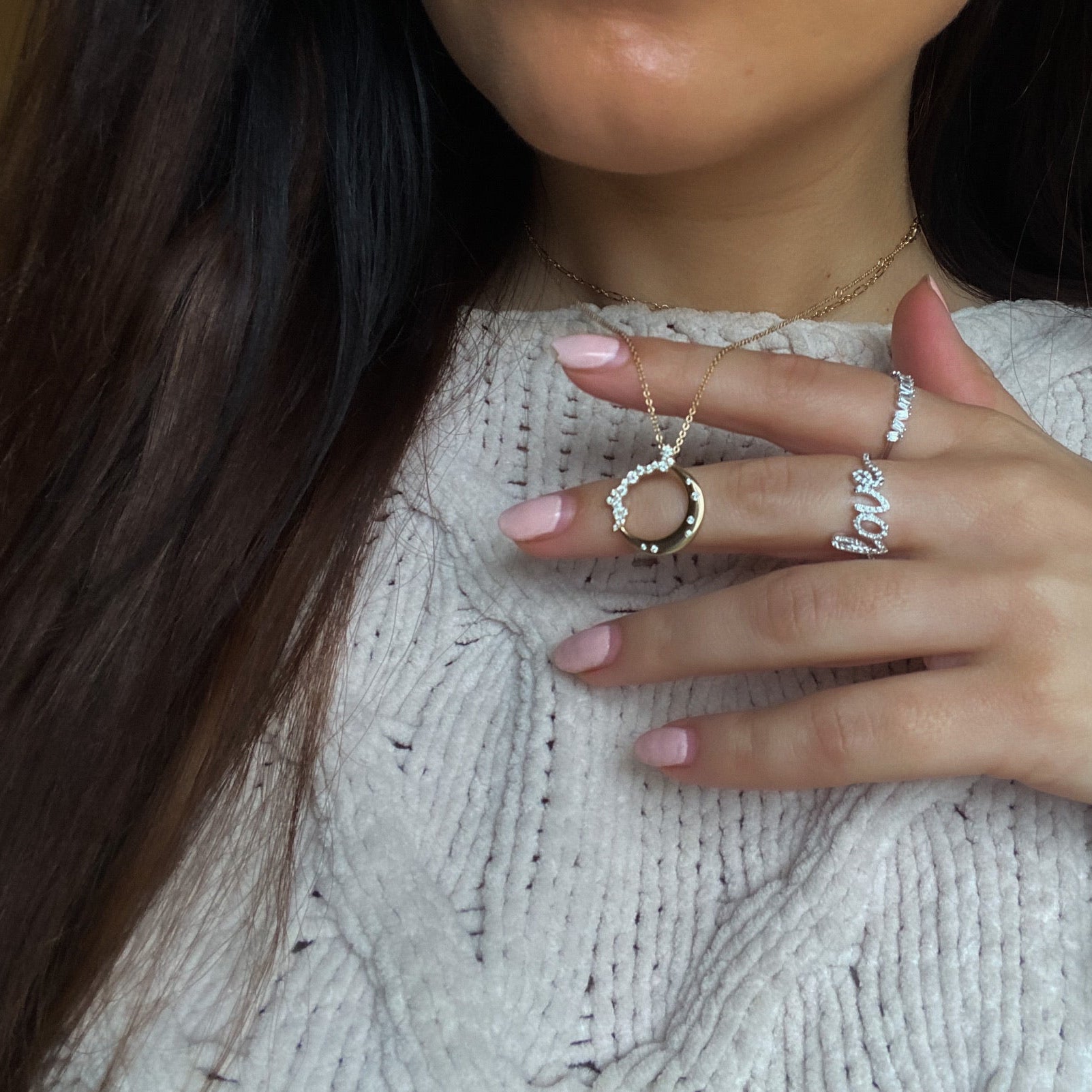 A woman wearing moon shaped 14k gold necklace with diamonds on a 14k gold chain